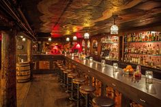 a bar with lots of bottles and stools