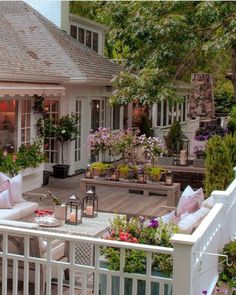 an outdoor patio with white furniture and flowers