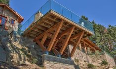 a glass and wood structure on top of a hill