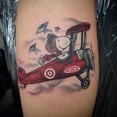 a cartoon dog is flying in an airplane tattoo on the right arm and shoulder,