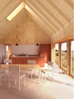 an open kitchen and dining area in a wooden structure with vaulted ceilings, windows, and wood flooring