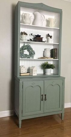 an old china cabinet painted green with white trim