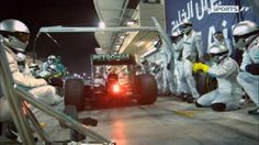 some people in white suits and helmets on a race track