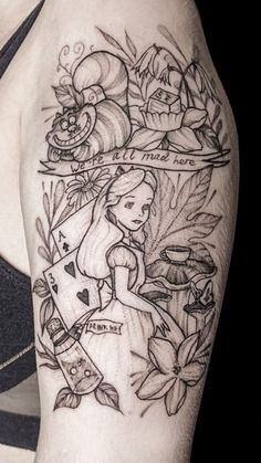 a woman's arm with tattoos on it and flowers in the background, including an alice