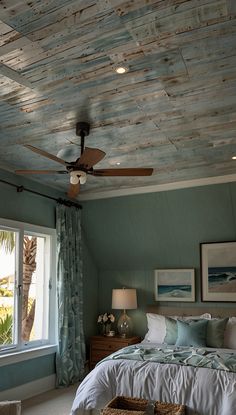 a bedroom with a bed, ceiling fan and two baskets in front of the window