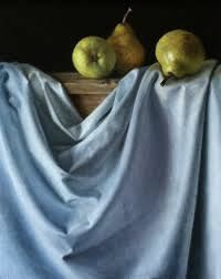 two pears sitting on top of a wooden table covered by a blue cloth next to an apple