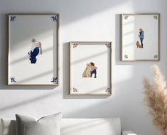 three framed pictures hang on the wall next to a white couch in a living room