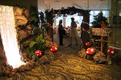 a group of people standing in front of a mushroom themed area with lights and decorations