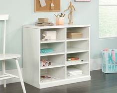 a white book shelf with books and papers on it