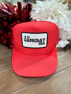 Red embroidered “In My Gameday Era” patch trucker hat. Mesh back with adjustable snap closure. One size fits most. Red Trucker Hat With Letter Print, Red Letter Print Snapback Trucker Hat, Red Trucker Hat With Letter Print And Curved Brim, Red Letter Print Trucker Hat For Baseball Season, Red Trucker Hat With Letter Print For Baseball Season, Red Snapback Trucker Hat For Game Day, Red Snapback Trucker Hat With Logo Patch, Red Trucker Hat With Letter Print And Flat Brim, Red 5-panel Hat With Letter Print