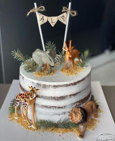 a cake decorated with animals and buntings on it's sides, including two giraffes