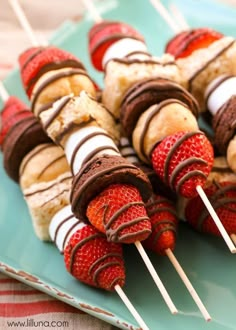 chocolate covered strawberries and bananas on skewers with marshmallows in the middle