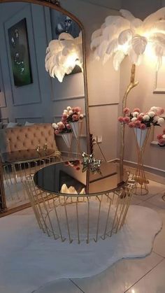 a mirror sitting on top of a white floor next to a table with flowers in it