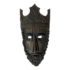 a mask with a crown on top of it's head and two holes in the middle