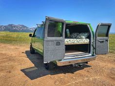 an off road vehicle with its bed in the back door open on a dirt road