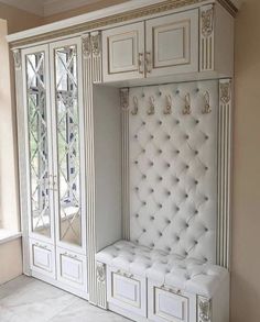 a white bench sitting in the middle of a room next to a wall mounted cabinet