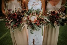 three bridesmaids holding their bouquets in the grass