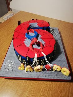 a spiderman themed birthday cake on a table