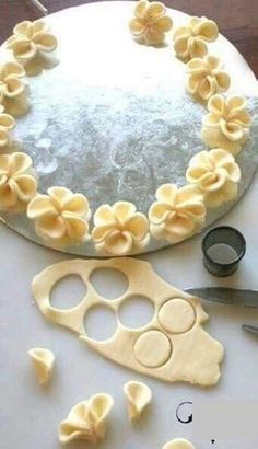 a cake that has been decorated with flowers and scissors on the table next to it