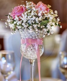 a vase filled with pink roses and baby's breath on top of a table