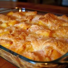 a casserole dish with peaches in it sitting on a wooden table top