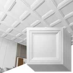 an empty room with white walls and ceiling tiles in the shape of rectangles