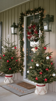 two decorated christmas trees sitting in front of a door