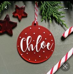 a red ornament with the word choe on it next to candy canes and christmas decorations