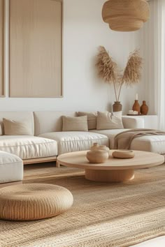 a living room filled with lots of white furniture and large paintings hanging on the wall