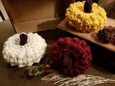 three crocheted pumpkins sitting on top of a table