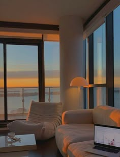 an open laptop computer sitting on top of a table in front of a living room window