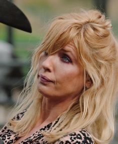 a close up of a person wearing a leopard print shirt and looking off into the distance