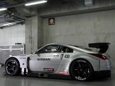 a silver nissan sports car parked in a garage