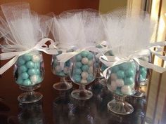 three glass vases filled with blue and white candies on top of a table