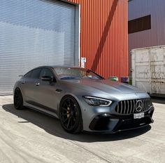 the mercedes amg coupe is parked in front of an industrial building with red shutters