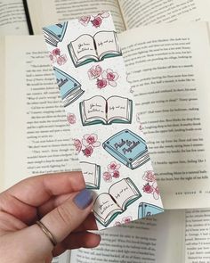 a person holding an open book with flowers on it and the pages in front of them