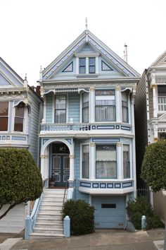 a blue house with white trim on the front and stairs leading up to it's entrance