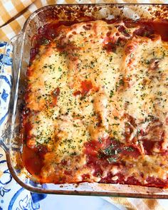 a casserole dish with meat and cheese in it sitting on a table cloth