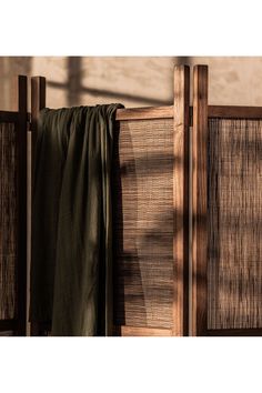 the curtain is hanging on the side of a wooden structure with sunlight coming through it