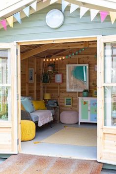 the inside of a small wooden shed with two couches and a chair in it