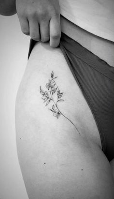 a woman's stomach with a small flower tattoo on the side of her belly