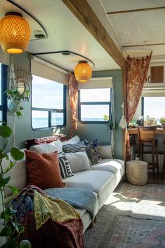 a living room filled with furniture and lots of windows next to a dining room table