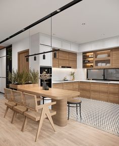 a modern kitchen with wooden cabinets and white walls, an island table surrounded by chairs