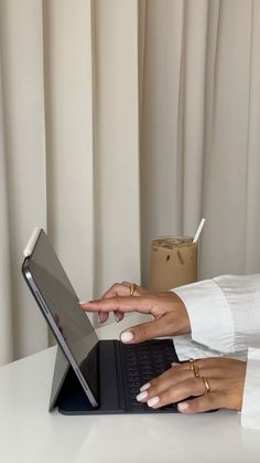 a woman sitting at a desk using a laptop computer with her hand on the keyboard