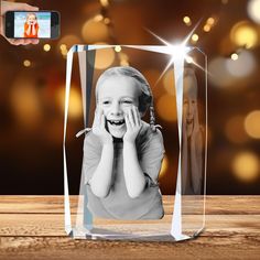 a glass photo frame with a child's face in the center and lights behind it