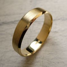 a gold wedding ring sitting on top of a table