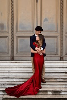 a young man and woman are embracing on the steps