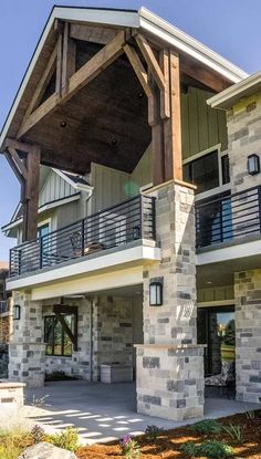 the front of a large house with stone pillars and balconies on each floor