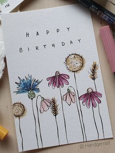 a happy birthday card with flowers on the front and bottom, surrounded by other items