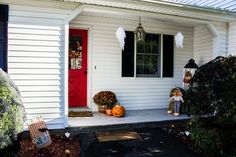 a white house with halloween decorations on the front porch